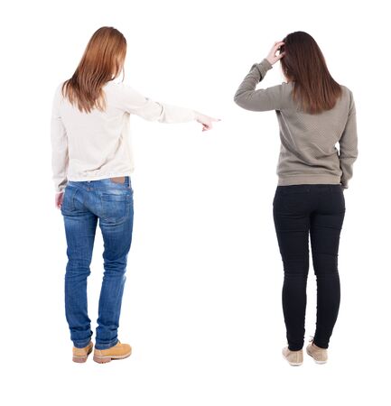 Back view of two pointing girl in sweater. Rear view people collection. backside view of person. beautiful woman showing gesture. Rear view. Isolated over white background.の写真素材