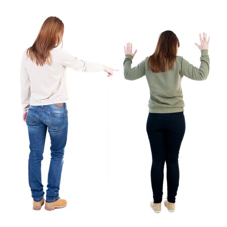 Back view of two pointing girl in sweater. Rear view people collection. backside view of person. beautiful woman showing gesture. Rear view. Isolated over white background.の写真素材