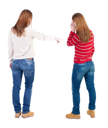 Back view of two young woman photographed on a mobile phone in sweater. Rear view people collection. backside view of person. Rear view. Isolated over white background.の写真素材