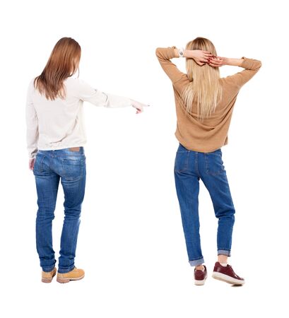 Back view of two pointing girl in sweater. Rear view people collection. backside view of person. beautiful woman showing gesture. Rear view. Isolated over white background.の写真素材