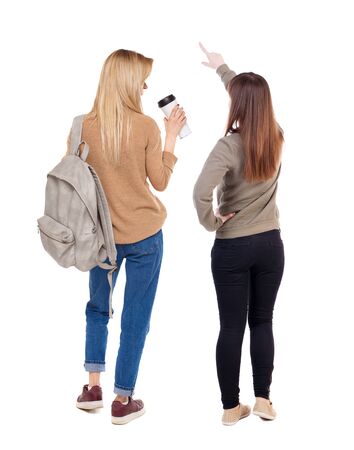 Back view of two pointing girl in sweater. Rear view people collection. backside view of person. beautiful woman showing gesture. Rear view. Isolated over white background.の写真素材