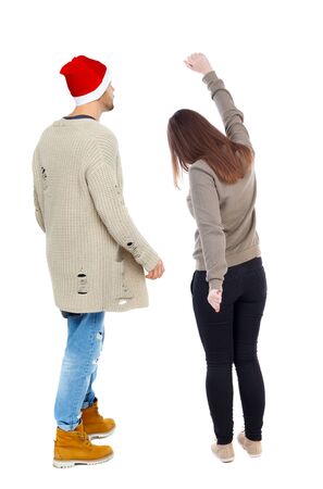 Back view of couple in sweater pointing. Rear view people collection. backside view of person. Isolated over white background.の写真素材