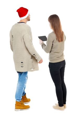 Back view of couple in sweater with mobile phone. beautiful friendly girl and guy together. Rear view people collection. backside view of person. Isolated over white background.の写真素材