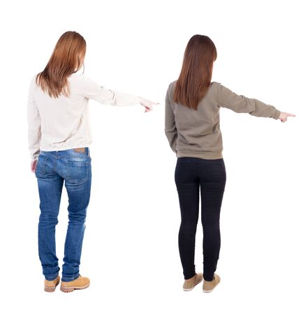 Back view of two pointing girl in sweater. Rear view people collection. backside view of person. beautiful woman showing gesture. Rear view. Isolated over white background.の写真素材