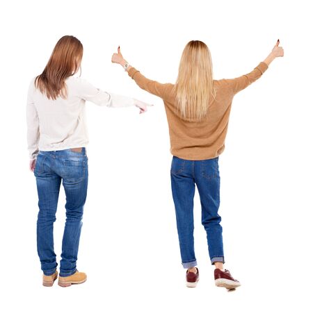 Back view of two pointing girl in sweater. Rear view people collection. backside view of person. beautiful woman showing gesture. Rear view. Isolated over white background.の写真素材