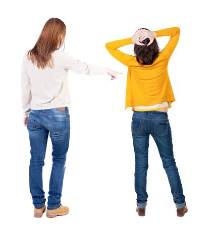 Back view of two pointing girl in sweater. Rear view people collection. backside view of person. beautiful woman showing gesture. Rear view. Isolated over white background.の写真素材