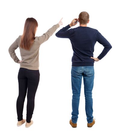 Back view of couple in sweater pointing. Rear view people collection. backside view of person. Isolated over white background.の写真素材