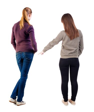 Back view of two pointing girl in sweater. Rear view people collection. backside view of person. beautiful woman showing gesture. Rear view. Isolated over white background.の写真素材