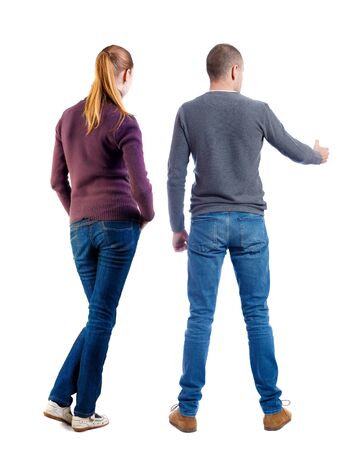 Back view of couple in sweater pointing. Rear view people collection. backside view of person. Isolated over white background.の写真素材