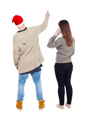 Back view of couple in sweater with mobile phone. beautiful friendly girl and guy together. Rear view people collection. backside view of person. Isolated over white background.の写真素材