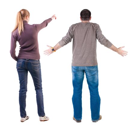 Back view of couple in sweater pointing. Rear view people collection. backside view of person. Isolated over white background.の写真素材