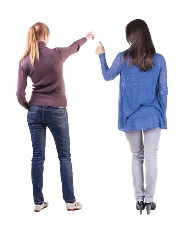 Back view of two pointing girl in sweater. Rear view people collection. backside view of person. beautiful woman showing gesture. Rear view. Isolated over white background.の写真素材