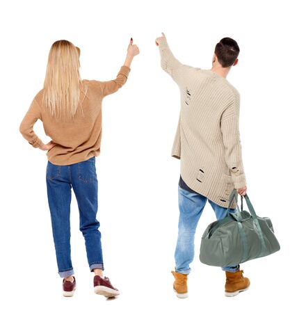 Back view of couple in sweater pointing. Rear view people collection. backside view of person. Isolated over white background.の写真素材
