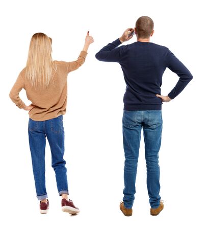 Back view of couple in sweater with mobile phone. beautiful friendly girl and guy together. Rear view people collection. backside view of person. Isolated over white background.の写真素材