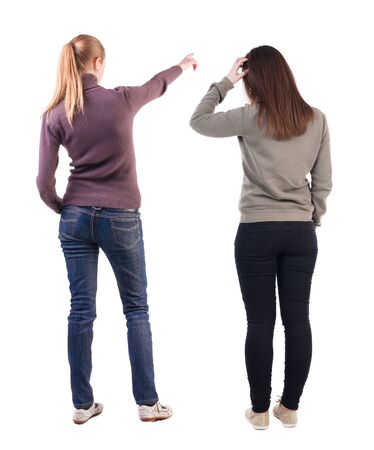 Back view of two pointing girl in sweater. Rear view people collection. backside view of person. beautiful woman showing gesture. Rear view. Isolated over white background.の写真素材
