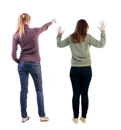 Back view of two pointing girl in sweater. Rear view people collection. backside view of person. beautiful woman showing gesture. Rear view. Isolated over white background.の写真素材