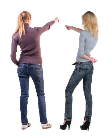 Back view of two pointing girl in sweater. Rear view people collection. backside view of person. beautiful woman showing gesture. Rear view. Isolated over white background.の写真素材