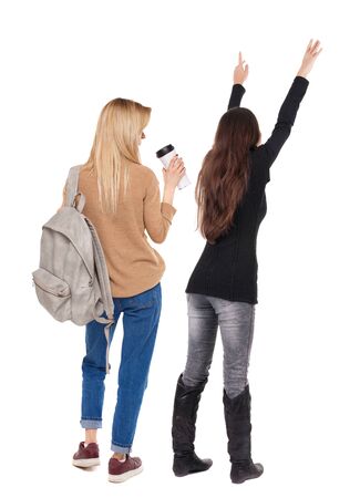 Back view of two pointing girl in sweater. Rear view people collection. backside view of person. beautiful woman showing gesture. Rear view. Isolated over white background.の写真素材