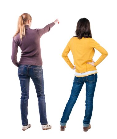 Back view of two pointing girl in sweater. Rear view people collection. backside view of person. beautiful woman showing gesture. Rear view. Isolated over white background.の写真素材