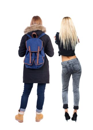 Back view of two young woman in winter jackets. Rear view people collection. backside view of person. Rear view. Isolated over white background. She clung to his girlfriendの写真素材
