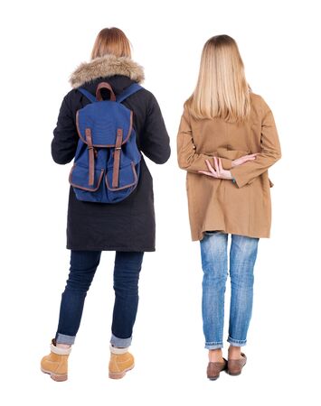 Back view of two young woman in winter jackets. Rear view people collection. backside view of person. Rear view. Isolated over white background. She clung to his girlfriendの写真素材