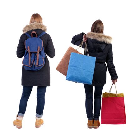 back view of two women with shopping bags in winter jacket. backside view of person. Rear view people collection. Isolated over white background.の写真素材