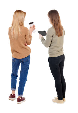 Back view of two young woman photographed on a mobile phone in sweater. Rear view people collection. backside view of person. Rear view. Isolated over white background.の写真素材