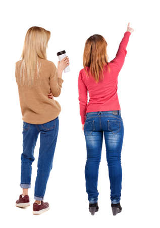 Back view of two pointing girl in sweater. Rear view people collection. backside view of person. beautiful woman showing gesture. Rear view. Isolated over white background.の写真素材