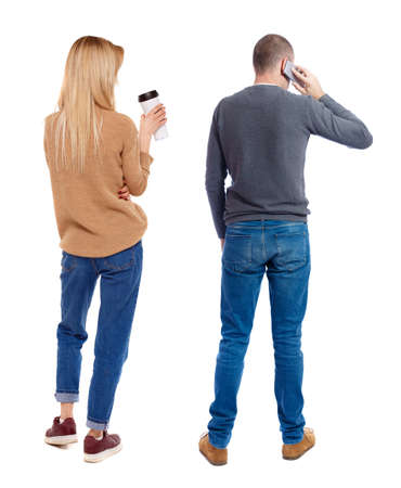 Back view of couple in sweater with mobile phone. beautiful friendly girl and guy together. Rear view people collection. backside view of person. Isolated over white background.の写真素材