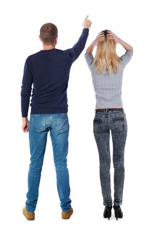 Back view of couple in sweater pointing. Rear view people collection. backside view of person. Isolated over white background.の写真素材
