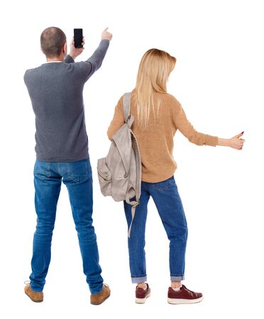 Back view of couple in sweater with mobile phone. beautiful friendly girl and guy together. Rear view people collection. backside view of person. Isolated over white background.の写真素材