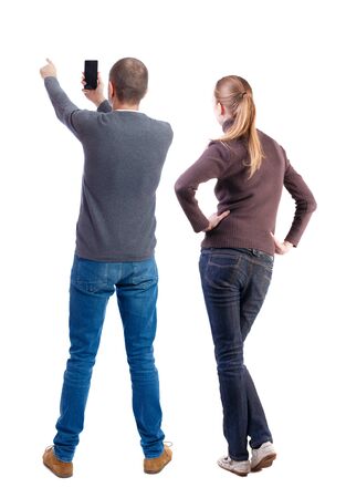 Back view of couple in sweater with mobile phone. beautiful friendly girl and guy together. Rear view people collection. backside view of person. Isolated over white background.の写真素材