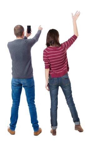 Back view of couple in sweater with mobile phone. beautiful friendly girl and guy together. Rear view people collection. backside view of person. Isolated over white background.の写真素材