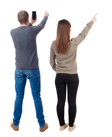 Back view of couple in sweater with mobile phone. beautiful friendly girl and guy together. Rear view people collection. backside view of person. Isolated over white background.の写真素材