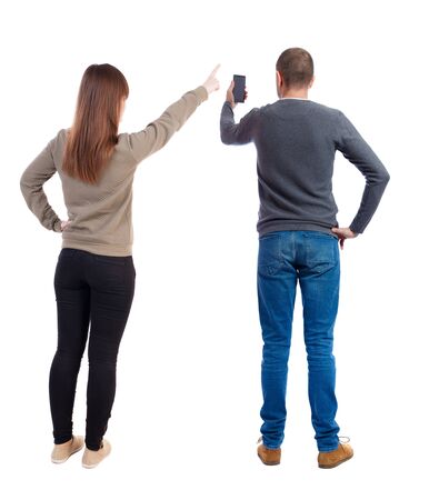 Back view of couple in sweater with mobile phone. beautiful friendly girl and guy together. Rear view people collection. backside view of person. Isolated over white background.の写真素材