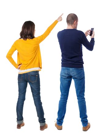Back view of couple in sweater with mobile phone. beautiful friendly girl and guy together. Rear view people collection. backside view of person. Isolated over white background.の写真素材