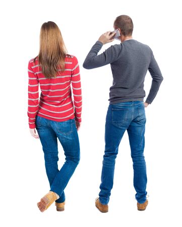 Back view of couple in sweater with mobile phone. beautiful friendly girl and guy together. Rear view people collection. backside view of person. Isolated over white background.の写真素材
