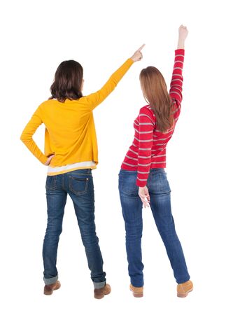 Back view of two young woman photographed on a mobile phone in sweater. Rear view people collection. backside view of person. Rear view. Isolated over white background.の写真素材