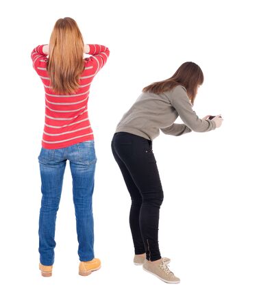 Back view of two young woman photographed on a mobile phone in sweater. Rear view people collection. backside view of person. Rear view. Isolated over white background.の写真素材