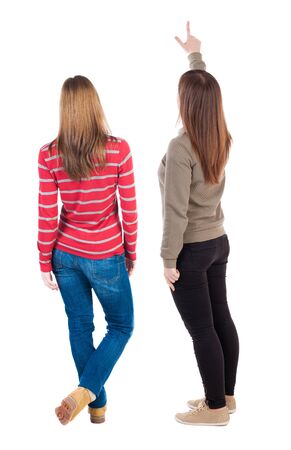 Back view of two young woman photographed on a mobile phone in sweater. Rear view people collection. backside view of person. Rear view. Isolated over white background.の写真素材