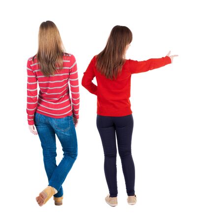 Back view of two young woman photographed on a mobile phone in sweater. Rear view people collection. backside view of person. Rear view. Isolated over white background.の写真素材