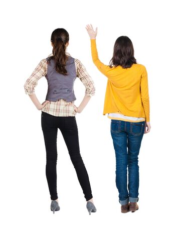 Back view of two young woman photographed on a mobile phone in sweater. Rear view people collection. backside view of person. Rear view. Isolated over white background.の写真素材