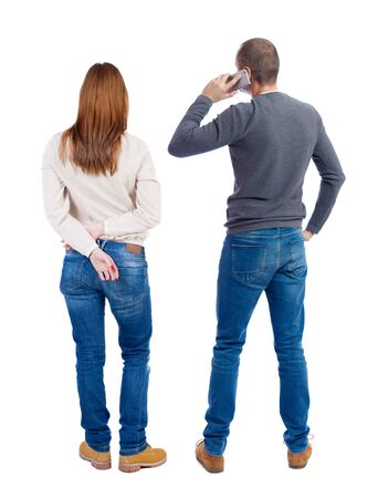 Back view of couple in sweater with mobile phone. beautiful friendly girl and guy together. Rear view people collection. backside view of person. Isolated over white background.の写真素材