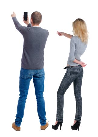 Back view of couple in sweater with mobile phone. beautiful friendly girl and guy together. Rear view people collection. backside view of person. Isolated over white background.の写真素材