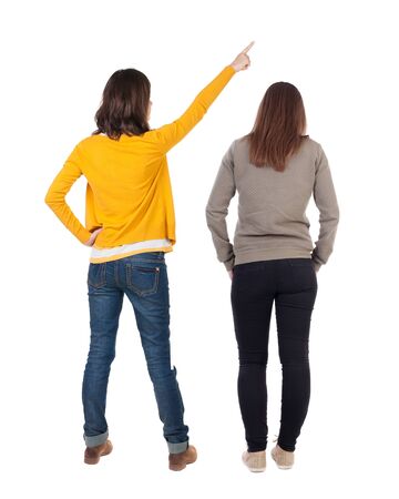 Back view of two young woman photographed on a mobile phone in sweater. Rear view people collection. backside view of person. Rear view. Isolated over white background.の写真素材