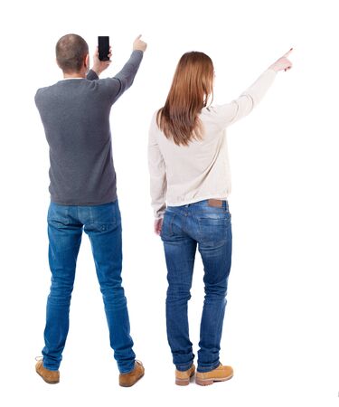 Back view of couple in sweater with mobile phone. beautiful friendly girl and guy together. Rear view people collection. backside view of person. Isolated over white background.の写真素材