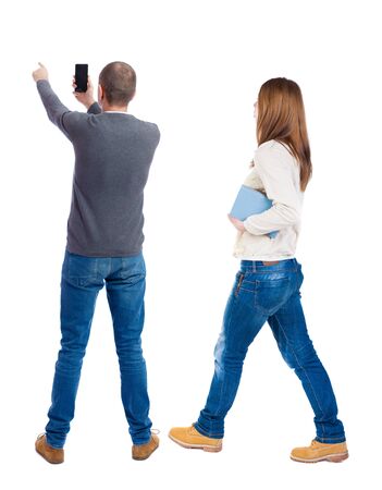 Back view of couple in sweater with mobile phone. beautiful friendly girl and guy together. Rear view people collection. backside view of person. Isolated over white background.の写真素材