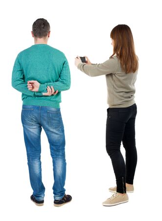 Back view of couple in sweater with mobile phone. beautiful friendly girl and guy together. Rear view people collection. backside view of person. Isolated over white background.の写真素材