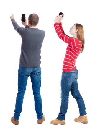 Back view of couple in sweater with mobile phone. beautiful friendly girl and guy together. Rear view people collection. backside view of person. Isolated over white background.の写真素材