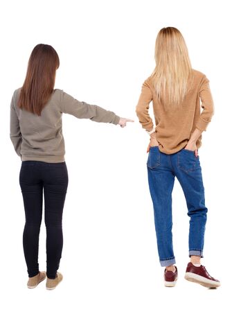 Back view of two young woman photographed on a mobile phone in sweater. Rear view people collection. backside view of person. Rear view. Isolated over white background.の写真素材